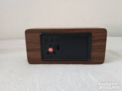 Drveni digitalni sat uz koji je priložen DC adapter.